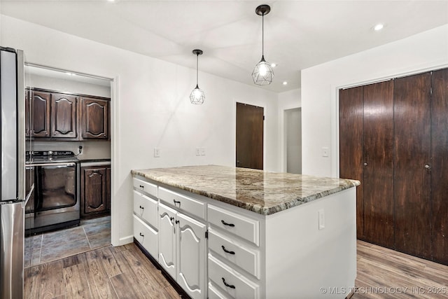 18251 145th W Ave, Sapulpa, OK 74066 - kitchen with a peninsula, washer / clothes dryer, dark brown cabinets, freestanding refrigerator, and light wood finished floors