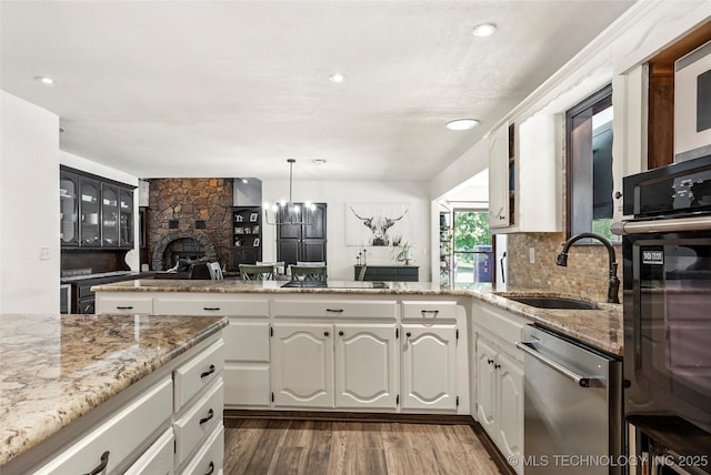 18251 145th W Ave, Sapulpa, OK 74066 - kitchen with black appliances, dark wood-style flooring, light stone counters, a fireplace, and white cabinetry