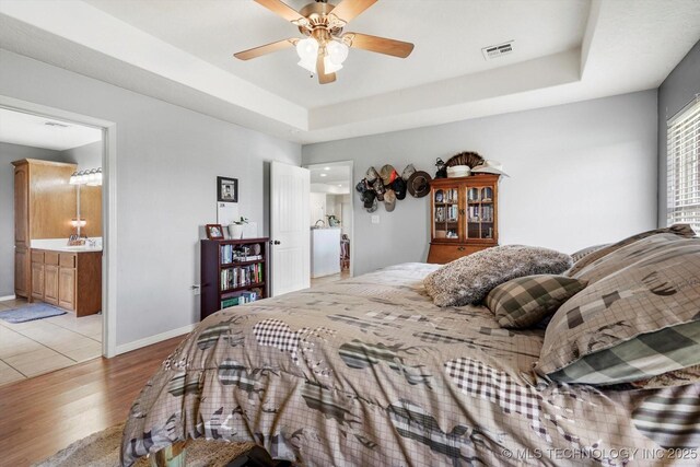 545 E 498th Cir, Pryor, OK 74361 - bedroom with light wood-style floors, a tray ceiling, and ceiling fan