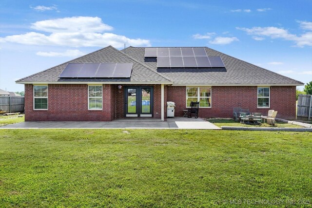 545 E 498th Cir, Pryor, OK 74361 - back of property with roof with shingles, a patio area, roof mounted solar panels, and brick siding