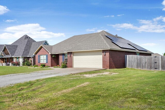 545 E 498th Cir, Pryor, OK 74361 - view of front facade featuring brick siding, a garage, concrete driveway, a shingled roof, and solar panels