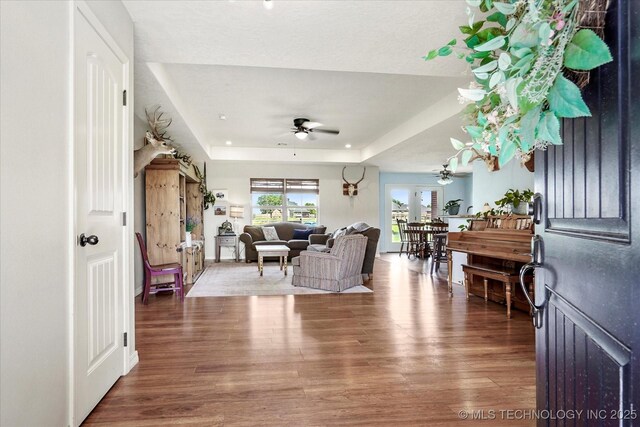 545 E 498th Cir, Pryor, OK 74361 - living room featuring ceiling fan, a tray ceiling, and wood finished floors