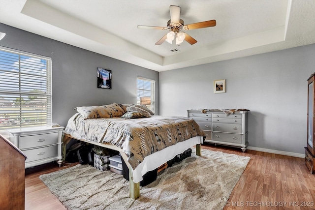 545 E 498th Cir, Pryor, OK 74361 - bedroom featuring a tray ceiling, wood finished floors, and a ceiling fan