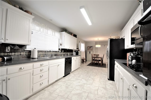 236 W 7th Ave, Bristow, OK 74010 - kitchen with black appliances, tasteful backsplash, white cabinetry, and plenty of natural light