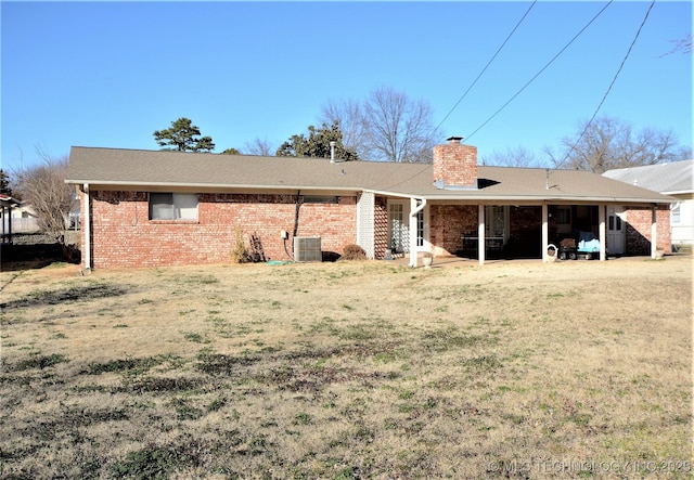 236 W 7th Ave, Bristow, OK 74010 - back of house featuring a chimney, brick siding, and a lawn