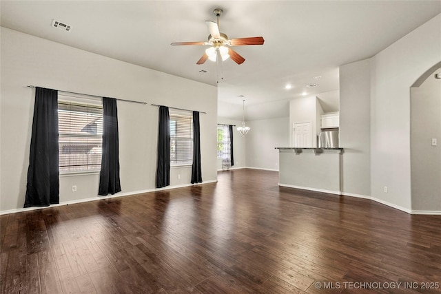 5612 N 31st St, Broken Arrow, OK 74014 - unfurnished living room featuring arched walkways, ceiling fan, dark wood-style flooring, a chandelier, and recessed lighting