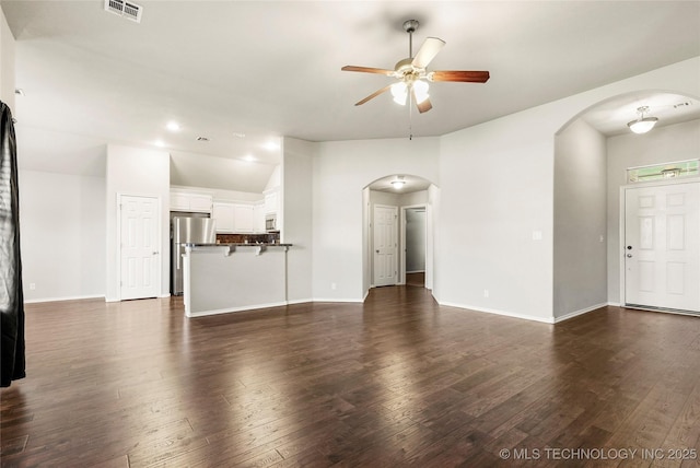 5612 N 31st St, Broken Arrow, OK 74014 - unfurnished living room featuring a ceiling fan, arched walkways, and dark wood-style flooring