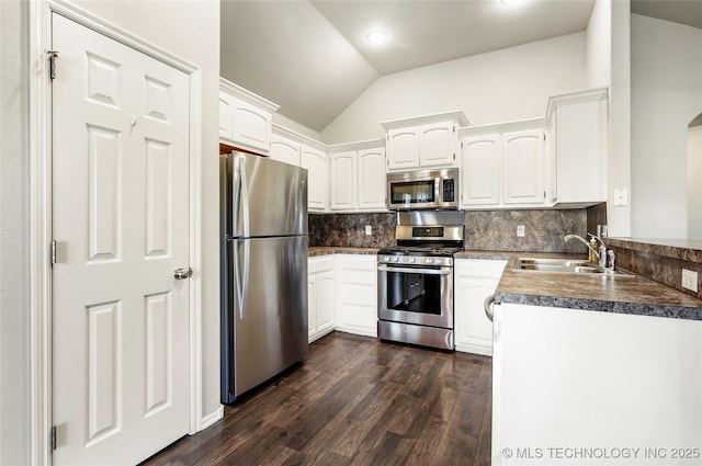 5612 N 31st St, Broken Arrow, OK 74014 - kitchen with appliances with stainless steel finishes, dark wood-style flooring, tasteful backsplash, vaulted ceiling, and white cabinets