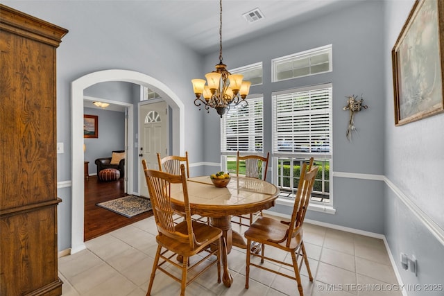 19722 E 50th Ct S, Broken Arrow, OK 74014 - dining area with arched walkways, a chandelier, and light tile patterned flooring