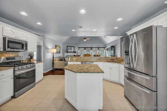 19722 E 50th Ct S, Broken Arrow, OK 74014 - kitchen with appliances with stainless steel finishes, vaulted ceiling, open floor plan, a peninsula, and white cabinets
