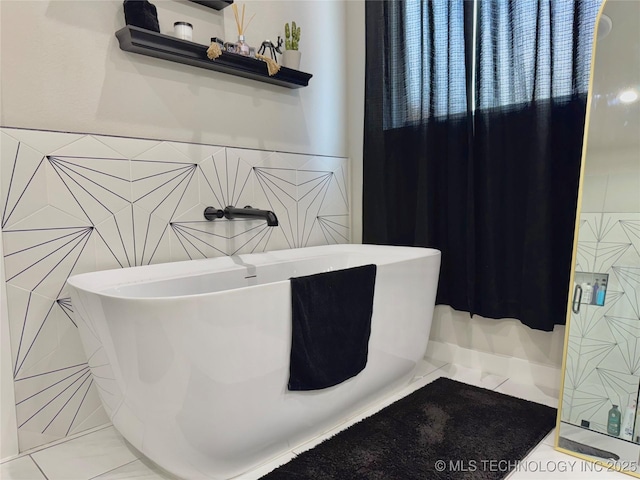3309 S 116th E Pl, Tulsa, OK 74146 - bathroom featuring tile walls, a freestanding bath, tile patterned flooring, and a wainscoted wall