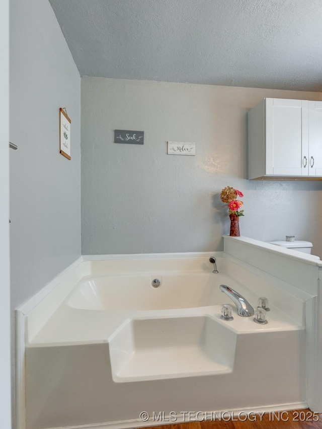 825 W 22nd St, Ada, OK 74820 - full bathroom with a garden tub and a textured ceiling