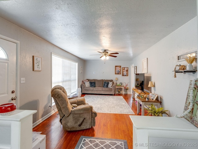 825 W 22nd St, Ada, OK 74820 - living room with plenty of natural light, wood finished floors, a textured ceiling, and a ceiling fan