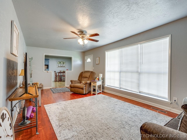 825 W 22nd St, Ada, OK 74820 - living area with wood finished floors, ceiling fan, and a textured ceiling