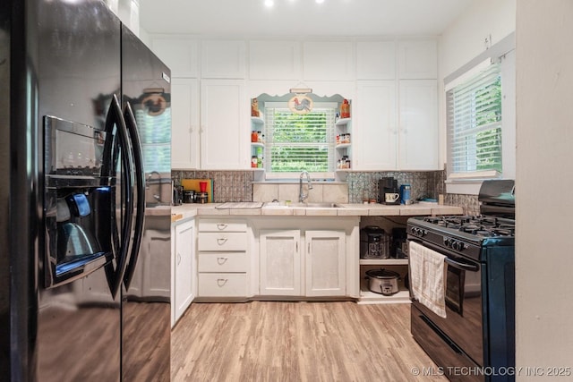 441059 E 155th Rd, Bluejacket, OK 74333 - kitchen with black appliances, open shelves, tile counters, white cabinets, and tasteful backsplash