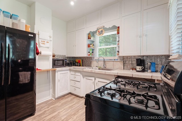 441059 E 155th Rd, Bluejacket, OK 74333 - kitchen featuring black appliances, tile countertops, white cabinetry, and backsplash