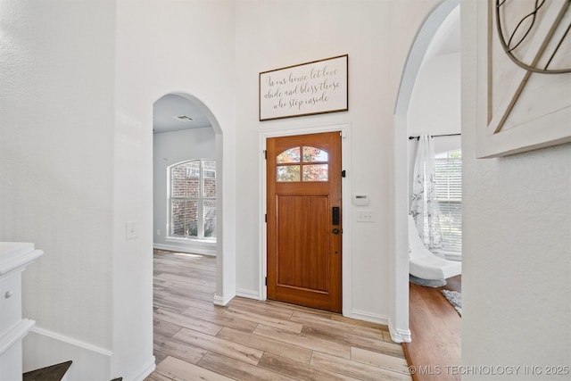 16410 E 49th St, Tulsa, OK 74134 - entryway featuring light wood-type flooring, arched walkways, and a towering ceiling