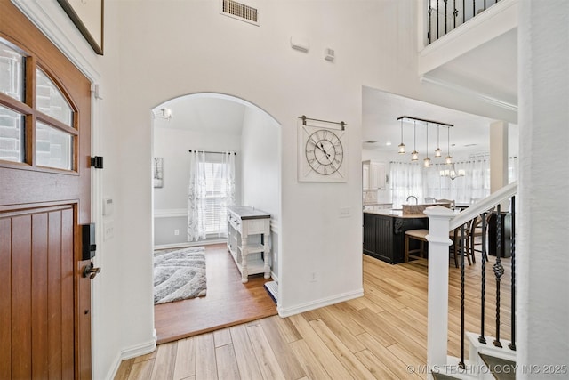 16410 E 49th St, Tulsa, OK 74134 - foyer with arched walkways, light wood-style flooring, and a high ceiling