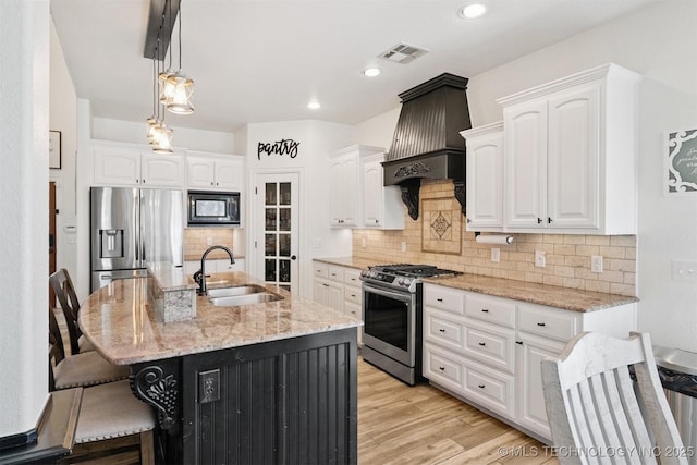 16410 E 49th St, Tulsa, OK 74134 - kitchen with stainless steel appliances, custom exhaust hood, a breakfast bar, white cabinetry, and light stone counters