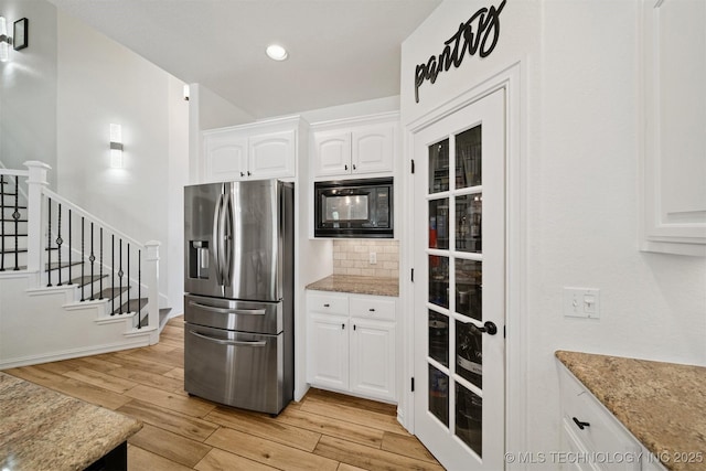 16410 E 49th St, Tulsa, OK 74134 - kitchen with stainless steel fridge, black microwave, light wood finished floors, white cabinets, and recessed lighting