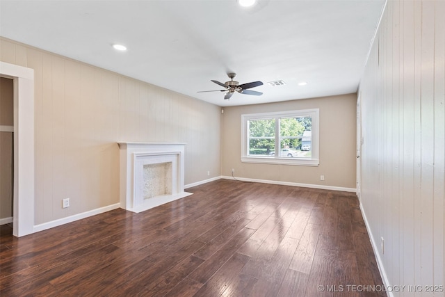 232 E Mohawk Blvd, Tulsa, OK 74106 - unfurnished living room with dark wood-style flooring, a ceiling fan, a fireplace with flush hearth, wood walls, and recessed lighting