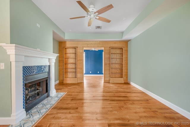 20409 E 49th St S, Broken Arrow, OK 74014 - unfurnished living room with built in features, a tiled fireplace, a ceiling fan, and wood finished floors