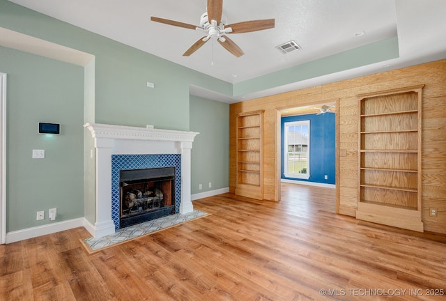 20409 E 49th St S, Broken Arrow, OK 74014 - unfurnished living room with ceiling fan, built in shelves, wood finished floors, and a tiled fireplace