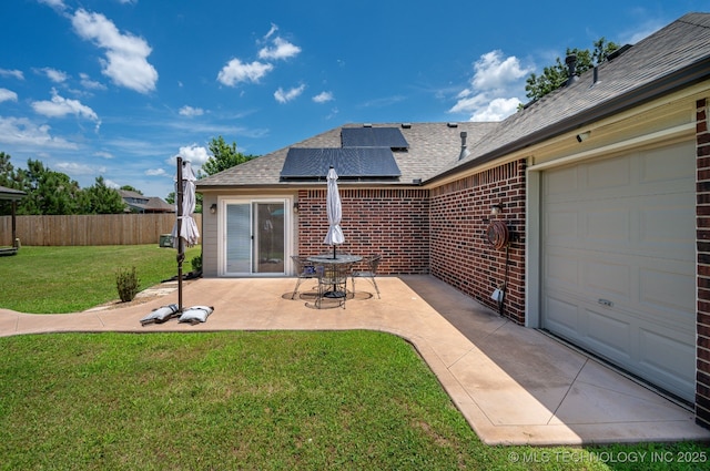 20409 E 49th St S, Broken Arrow, OK 74014 - back of property with roof with shingles, solar panels, brick siding, a patio area, and an attached garage