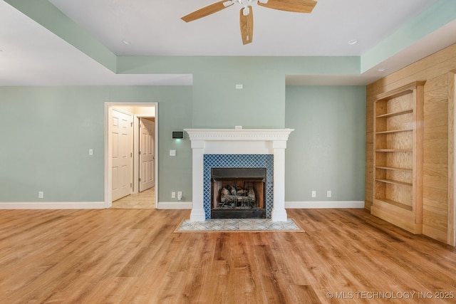 20409 E 49th St S, Broken Arrow, OK 74014 - unfurnished living room with built in shelves, a fireplace, a ceiling fan, and wood finished floors