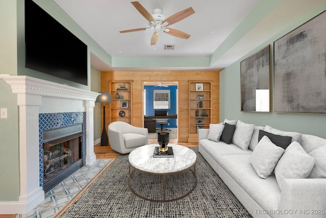 20409 E 49th St S, Broken Arrow, OK 74014 - living room featuring built in shelves, ceiling fan, and a tiled fireplace