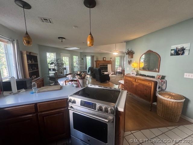 7412 W 38th St, Tulsa, OK 74107 - kitchen with electric range, open floor plan, a textured ceiling, light countertops, and plenty of natural light