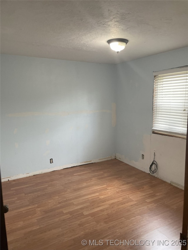 55250 E 297th Rd, Afton, OK 74331 - spare room with wood finished floors and a textured ceiling