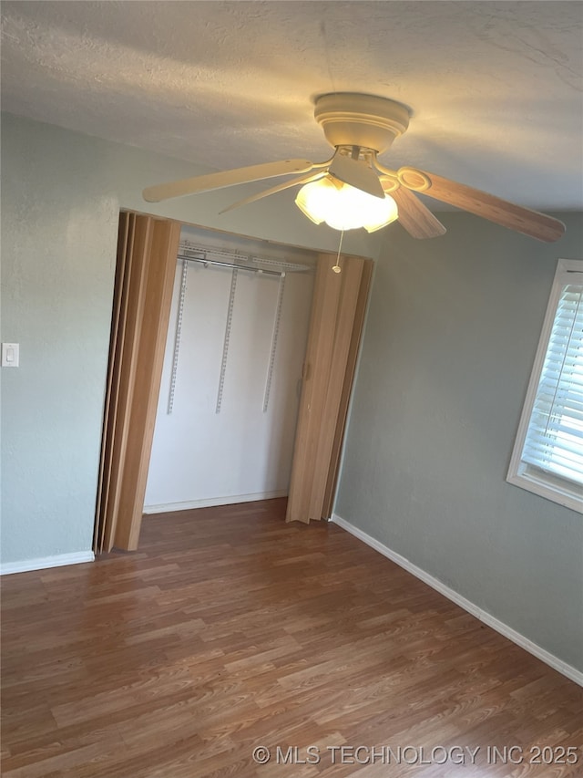 55250 E 297th Rd, Afton, OK 74331 - unfurnished bedroom featuring wood finished floors, a closet, ceiling fan, and a textured ceiling