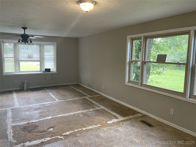 55250 E 297th Rd, Afton, OK 74331 - empty room featuring plenty of natural light, a ceiling fan, and a textured ceiling