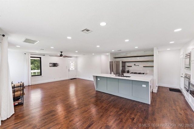33966 S 4310th Rd, Big Cabin, OK 74332 - kitchen featuring light countertops, oven, ceiling fan, a kitchen island with sink, and dark wood-style flooring