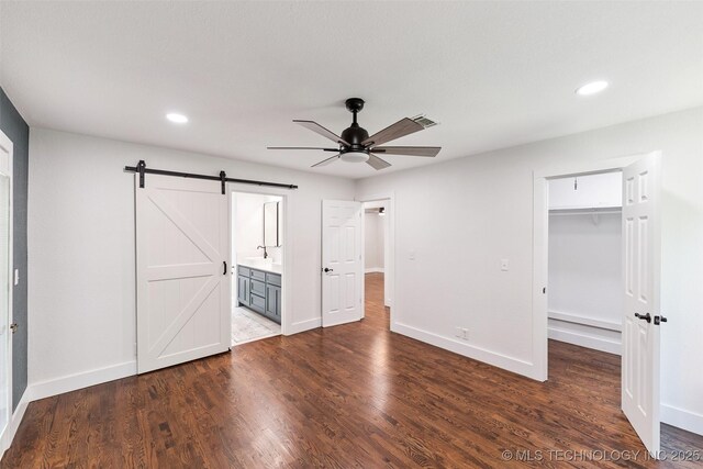 33966 S 4310th Rd, Big Cabin, OK 74332 - unfurnished bedroom with a barn door, a walk in closet, recessed lighting, dark wood-style floors, and a closet