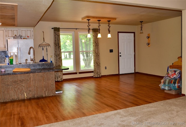 27855 S 170th Rd, Henryetta, OK 74437 - kitchen featuring white refrigerator with ice dispenser, hanging light fixtures, wood finished floors, dark countertops, and white cabinetry