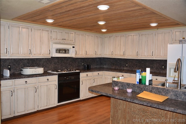 27855 S 170th Rd, Henryetta, OK 74437 - kitchen with white microwave, black gas range oven, wood ceiling, dark countertops, and wood finished floors