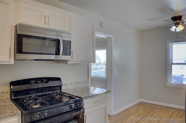 3833 E 22nd St, Tulsa, OK 74114 - kitchen with stainless steel appliances, light wood finished floors, a ceiling fan, white cabinetry, and light stone countertops