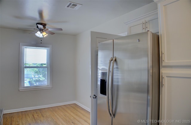 3833 E 22nd St, Tulsa, OK 74114 - kitchen featuring stainless steel fridge, ceiling fan, light wood-style floors, and white cabinetry