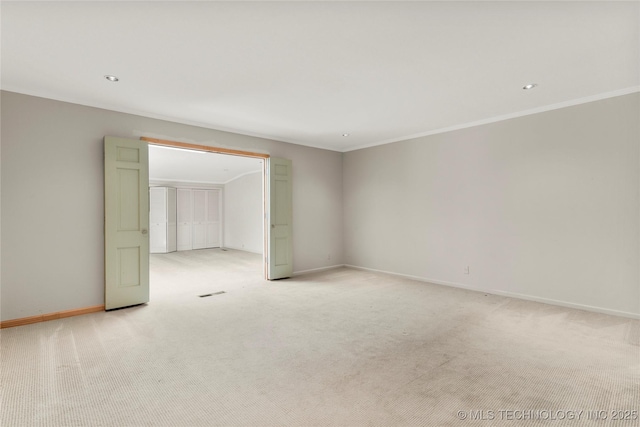empty room featuring light colored carpet, recessed lighting, and crown molding