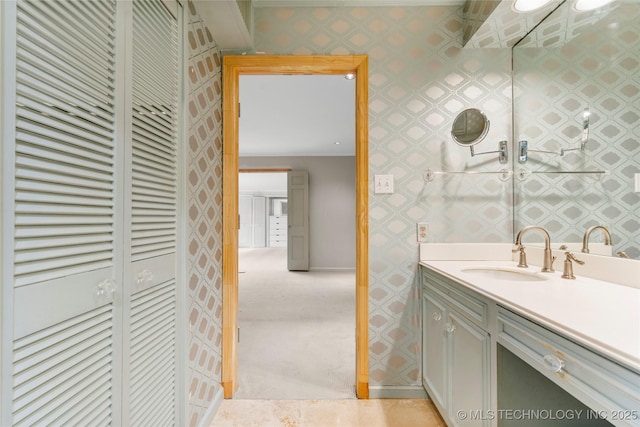bathroom featuring vanity, wallpapered walls, and a closet