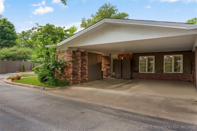 view of front of property with an attached carport, brick siding, and concrete driveway