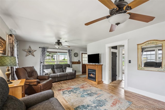 606 Goingsnake St, Tahlequah, OK 74464 - living room featuring ceiling fan, light wood finished floors, and a glass covered fireplace
