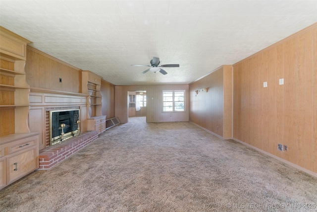 522 E 6th St, Claremore, OK 74017 - unfurnished living room with ceiling fan, a brick fireplace, carpet floors, and wooden walls
