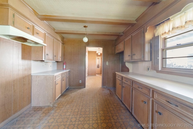 522 E 6th St, Claremore, OK 74017 - kitchen with wood walls, beam ceiling, light countertops, tile patterned floors, and under cabinet range hood
