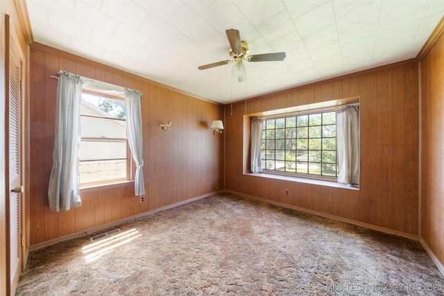 522 E 6th St, Claremore, OK 74017 - carpeted empty room with healthy amount of natural light, ceiling fan, and wood walls