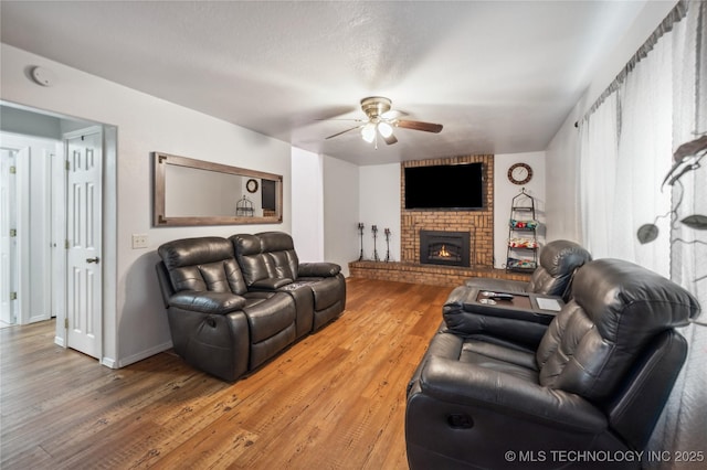 1105 S Maple Ave, Tahlequah, OK 74464 - living area featuring ceiling fan, light wood-type flooring, and a brick fireplace