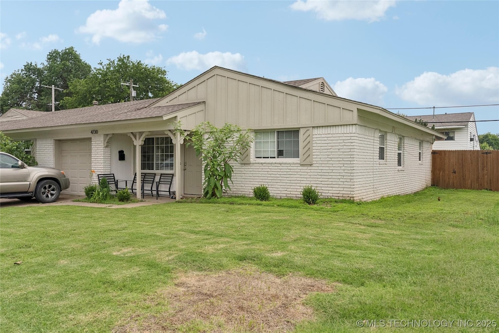 313 E 48th Ave, Tulsa, OK 74105 - view of front facade with an attached garage, board and batten siding, and brick siding