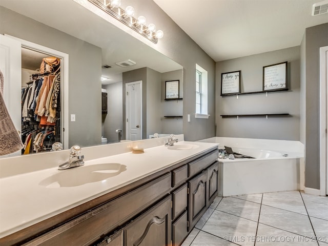 1604 W Los Angeles Cir, Broken Arrow, OK 74011 - bathroom featuring double vanity, a garden tub, and a spacious closet